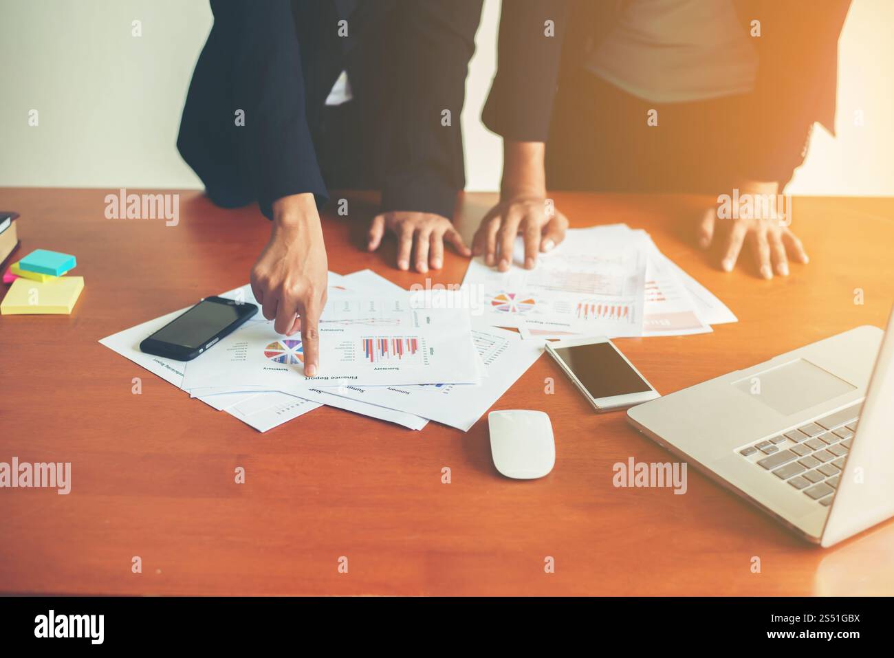 Team Business - professionisti che lavorano insieme alla scrivania in legno dell'ufficio, primo piano con l'indicazione dei dati finanziari su un report. Attività di squadra Foto Stock