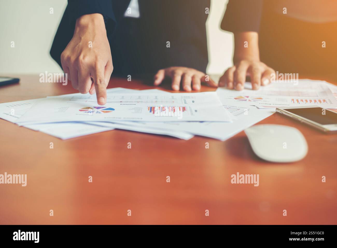 Team Business - professionisti che lavorano insieme alla scrivania in legno dell'ufficio, primo piano con l'indicazione dei dati finanziari su un report. Attività di squadra Foto Stock