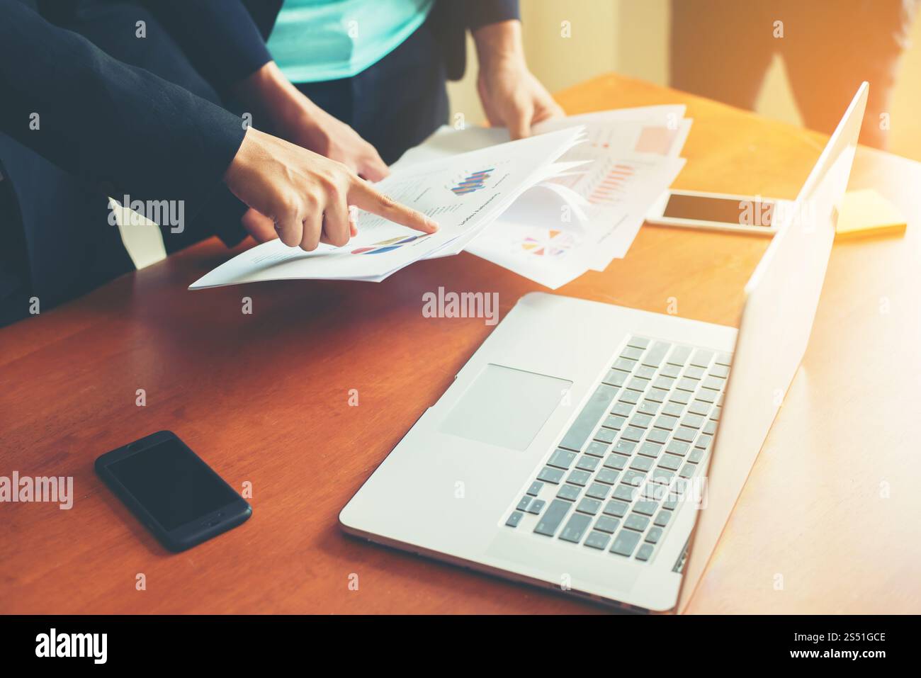 Team Business - professionisti che lavorano insieme alla scrivania in legno dell'ufficio, primo piano con l'indicazione dei dati finanziari su un report. Attività di squadra Foto Stock
