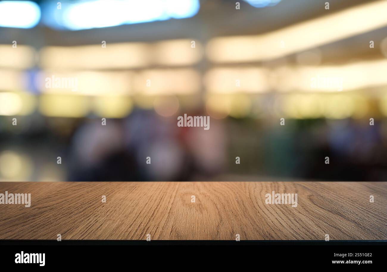 Tavolo vuoto di legno scuro davanti allo sfondo bokeh astratto e sfocato del ristorante. può essere utilizzato per la visualizzazione o il montaggio dei prodotti. Mock-up per Foto Stock