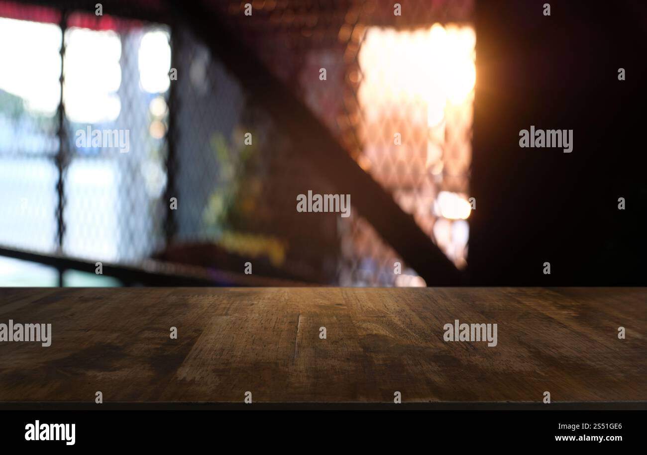 Tavolo vuoto di legno scuro davanti allo sfondo bokeh astratto e sfocato del ristorante. può essere utilizzato per la visualizzazione o il montaggio dei prodotti. Mock-up per Foto Stock