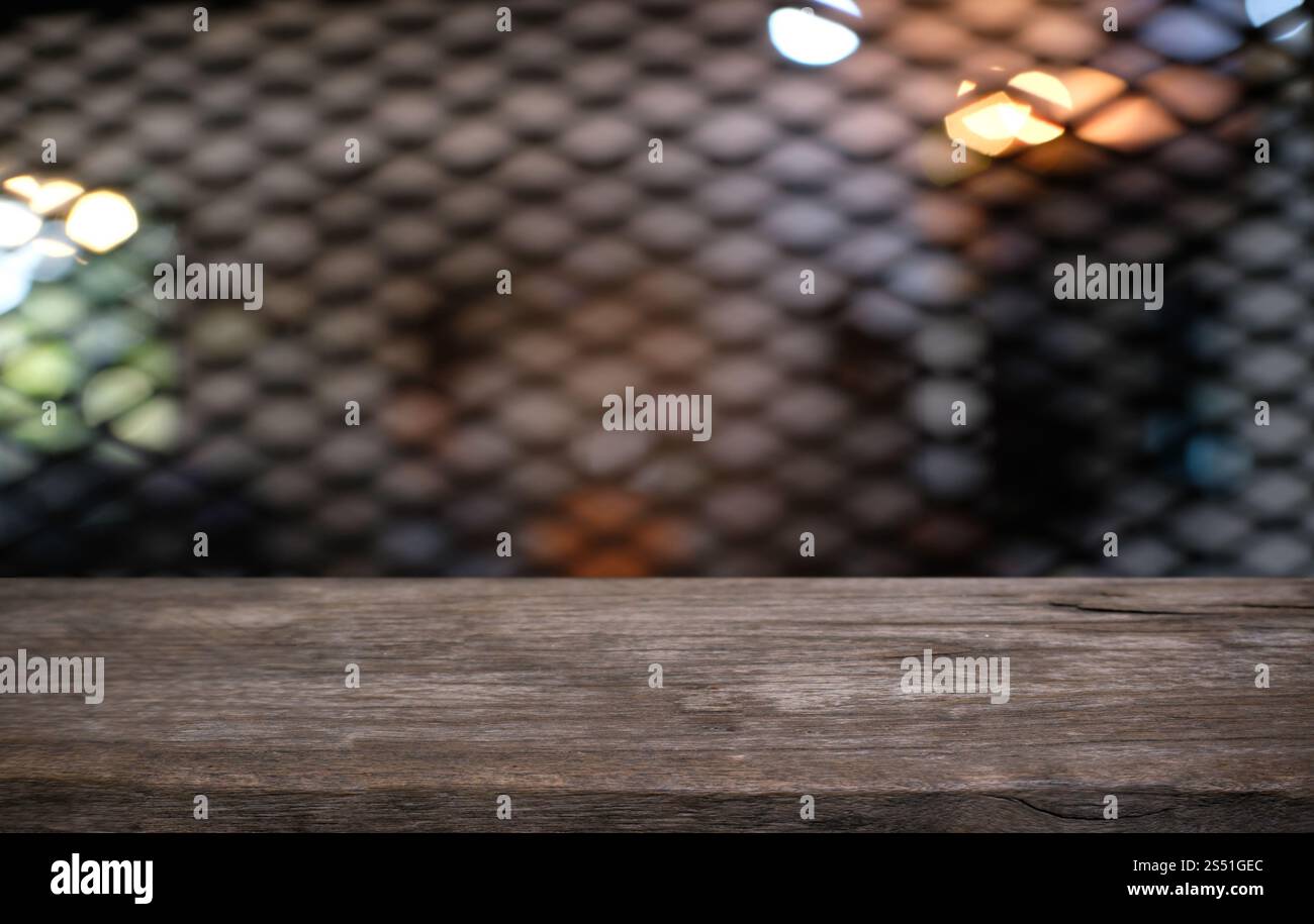 Tavolo vuoto di legno scuro davanti allo sfondo bokeh astratto e sfocato del ristorante. può essere utilizzato per la visualizzazione o il montaggio dei prodotti. Mock-up per Foto Stock