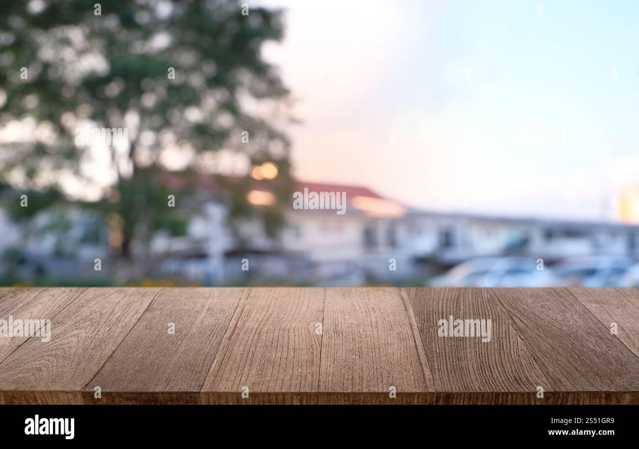 Tavolo vuoto di legno scuro davanti allo sfondo bokeh astratto e sfocato del ristorante. può essere utilizzato per la visualizzazione o il montaggio dei prodotti. Mock-up per Foto Stock