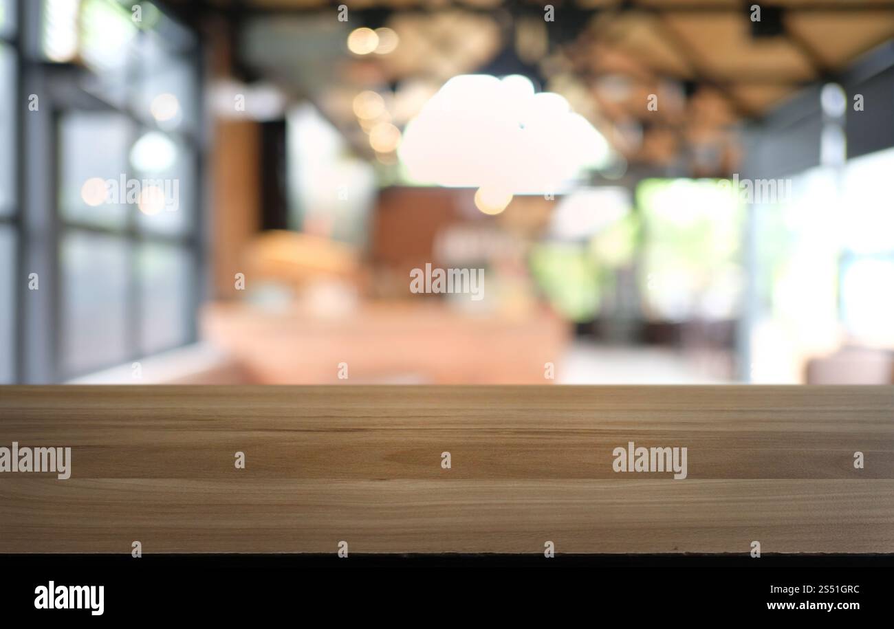 Tavolo vuoto di legno scuro davanti allo sfondo bokeh astratto e sfocato del ristorante. può essere utilizzato per la visualizzazione o il montaggio dei prodotti. Mock-up per Foto Stock