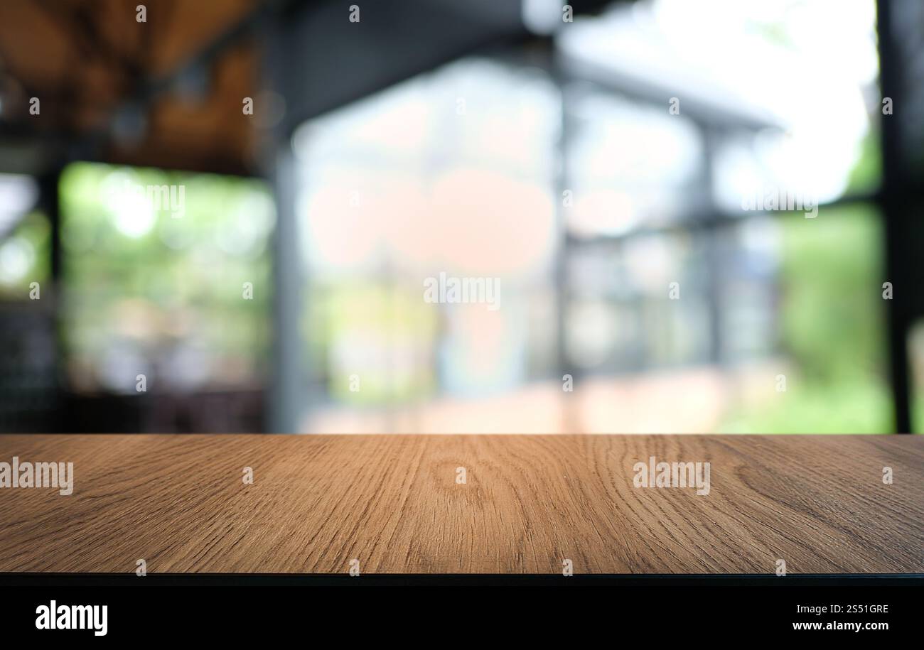 Tavolo vuoto di legno scuro davanti allo sfondo bokeh astratto e sfocato del ristorante. può essere utilizzato per la visualizzazione o il montaggio dei prodotti. Mock-up per Foto Stock
