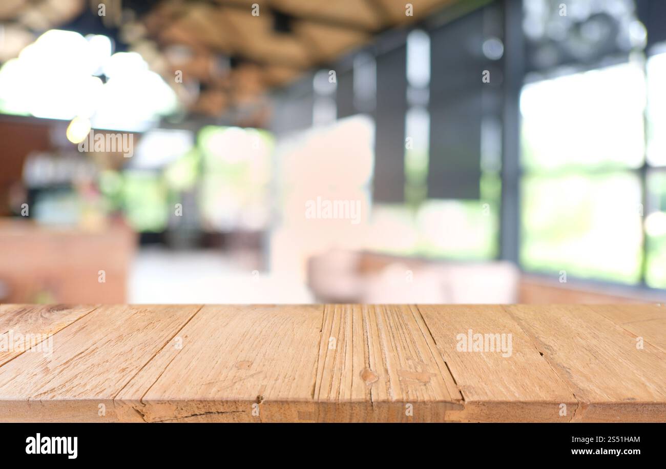 Tavolo vuoto di legno scuro davanti allo sfondo bokeh astratto e sfocato del ristorante. può essere utilizzato per la visualizzazione o il montaggio dei prodotti. Mock-up per Foto Stock