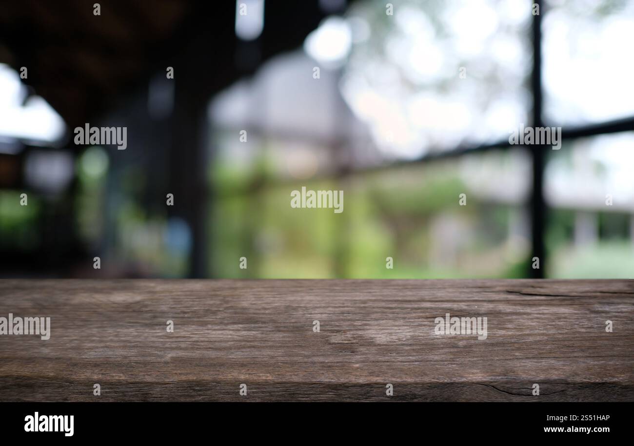 Tavolo vuoto di legno scuro davanti allo sfondo bokeh astratto e sfocato del ristorante. può essere utilizzato per la visualizzazione o il montaggio dei prodotti. Mock-up per Foto Stock