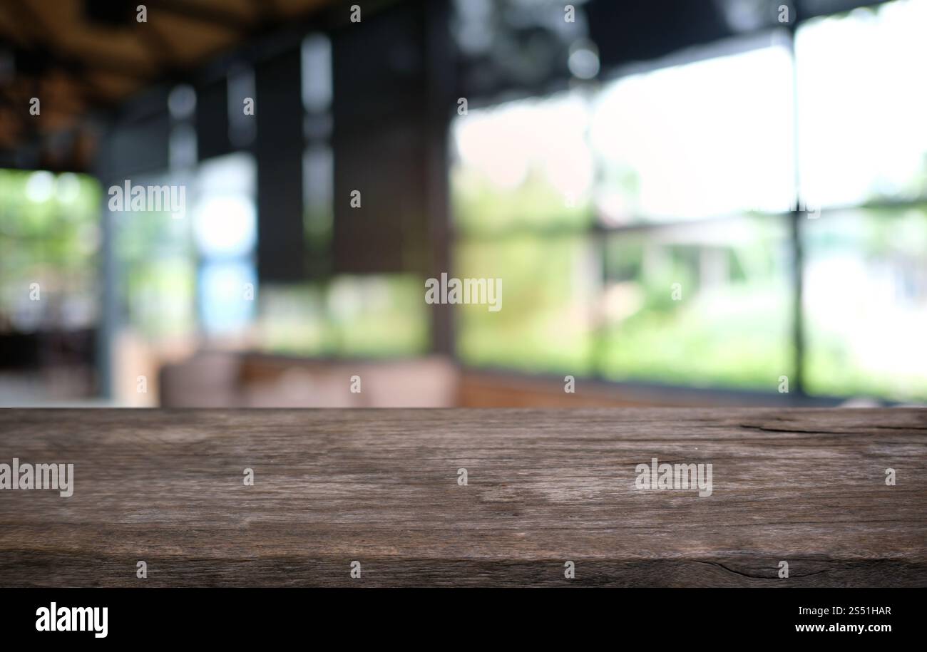 Tavolo vuoto di legno scuro davanti allo sfondo bokeh astratto e sfocato del ristorante. può essere utilizzato per la visualizzazione o il montaggio dei prodotti. Mock-up per Foto Stock