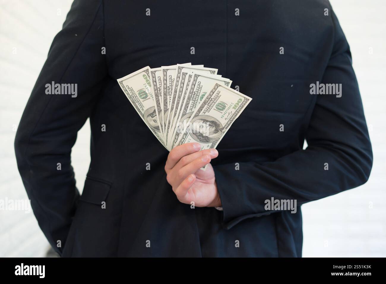 Ritratto di un uomo d'affari che tiene soldi e nasconderli. Foto Stock
