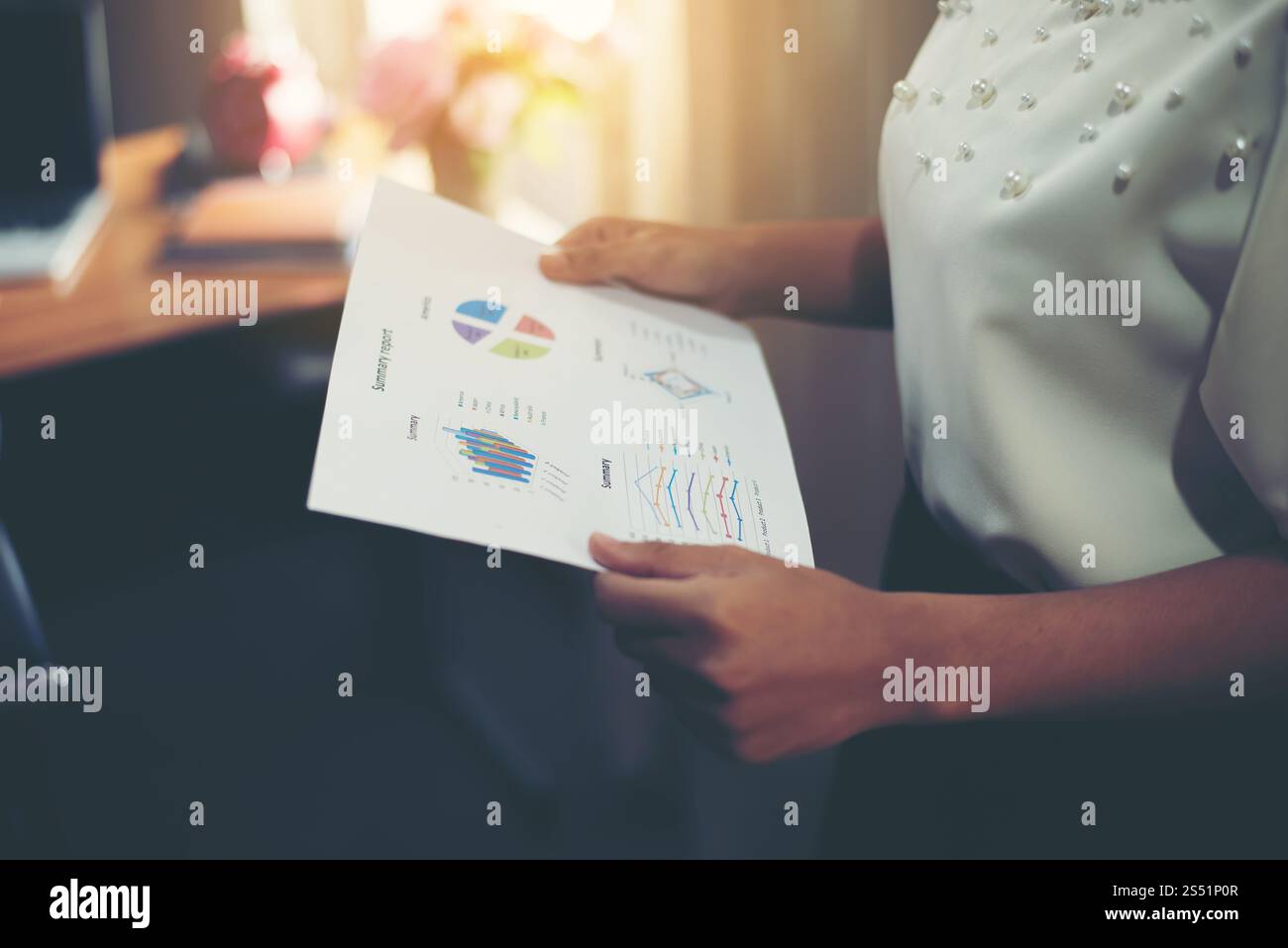 segretario in piedi a guardare il grafico finanziario in ufficio. Foto Stock