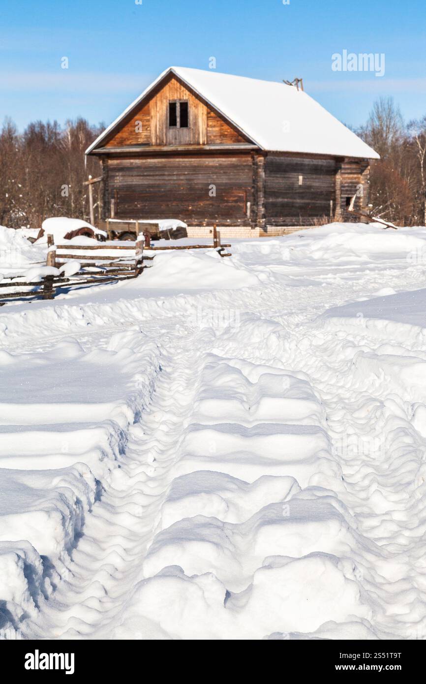 Coperte di neve road nel villaggio russo Kikino a Smolensk Oblast della Russia nella soleggiata giornata invernale Foto Stock