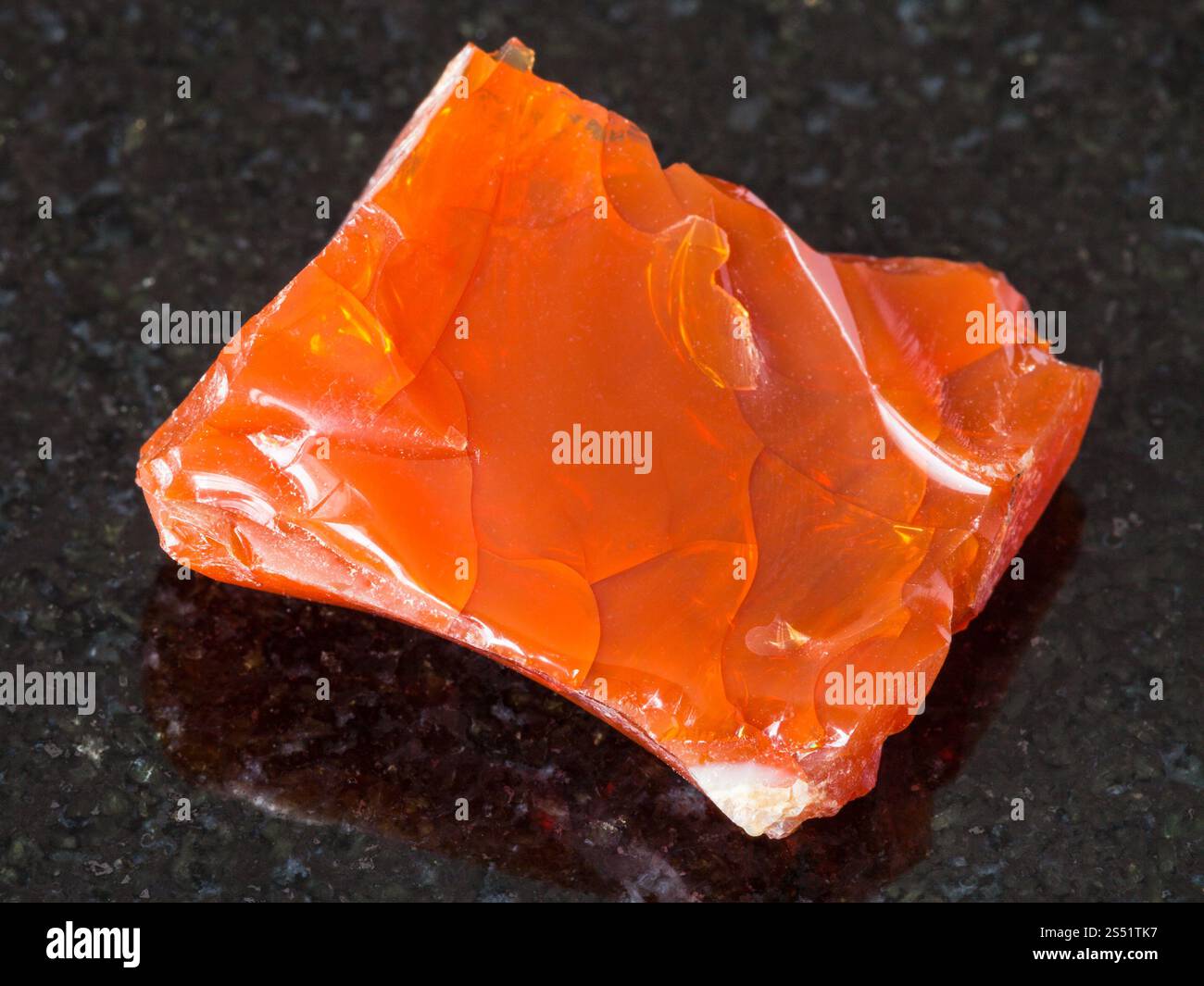 Le riprese in modalità macro di minerali naturali - ruvida opale di fuoco gem sulla pietra di granito nero da Monti Urali Foto Stock