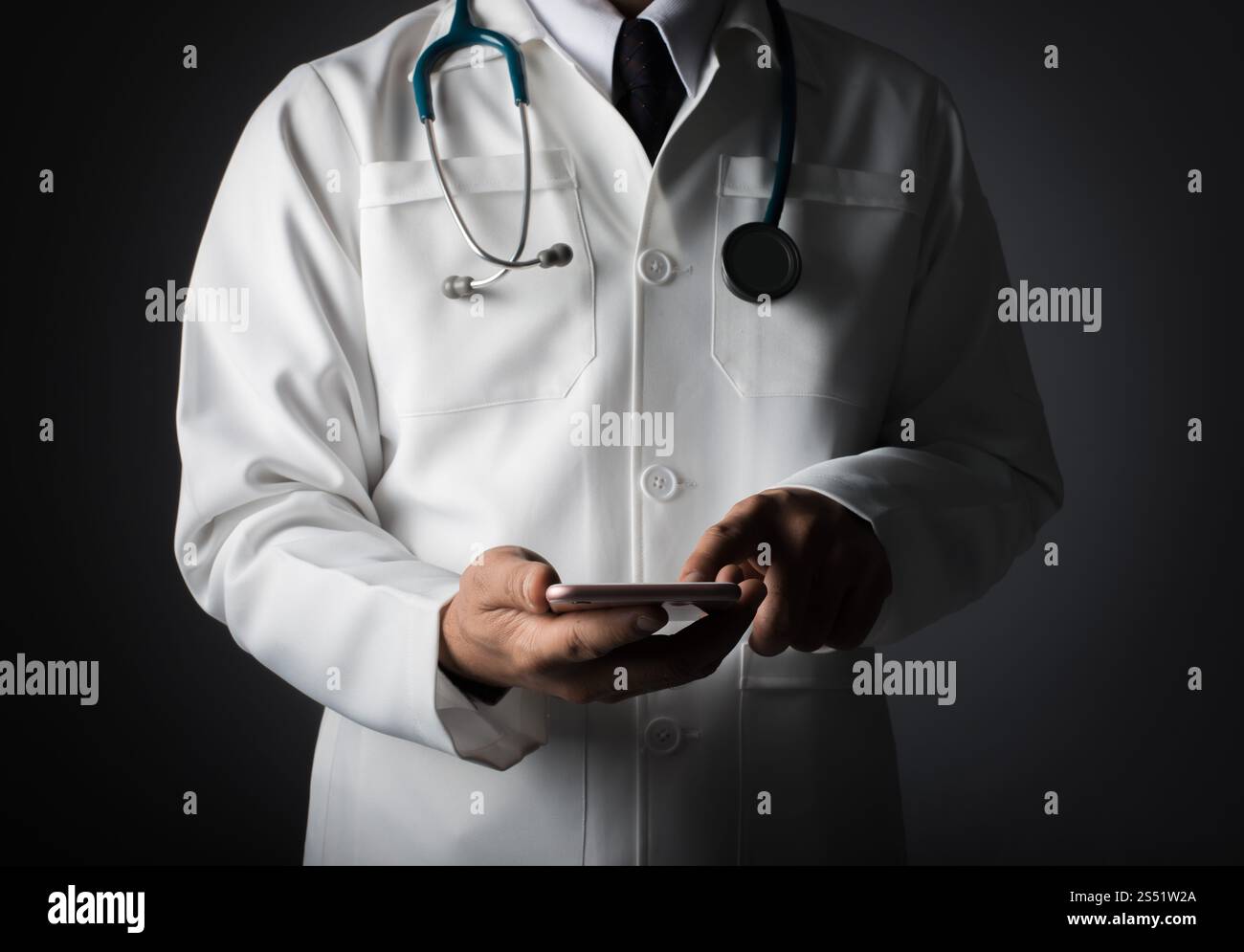 Il medico maschile in camice bianco sta utilizzando un moderno dispositivo smartphone wi. Il medico maschile in camice bianco sta utilizzando un moderno dispositivo smartphone con touch screen. Foto Stock