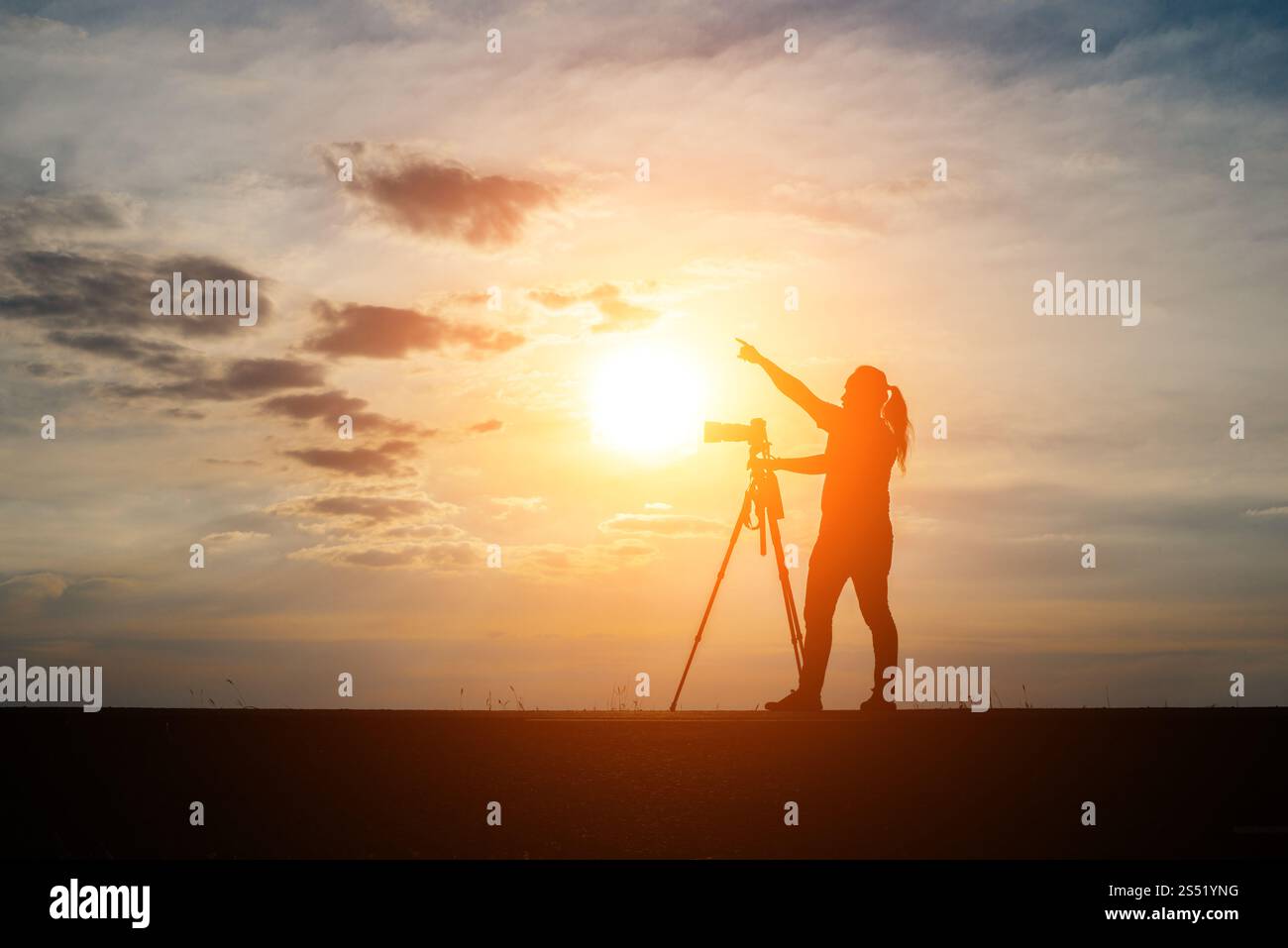Silhouette di un fotografo spara un tramonto. Foto Stock