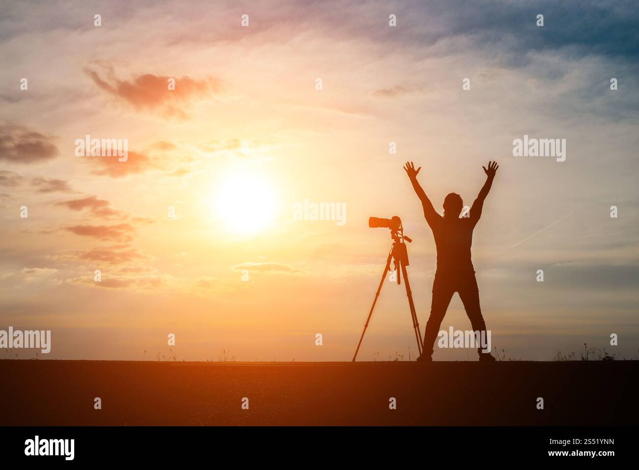 Silhouette di un fotografo spara un tramonto. Foto Stock