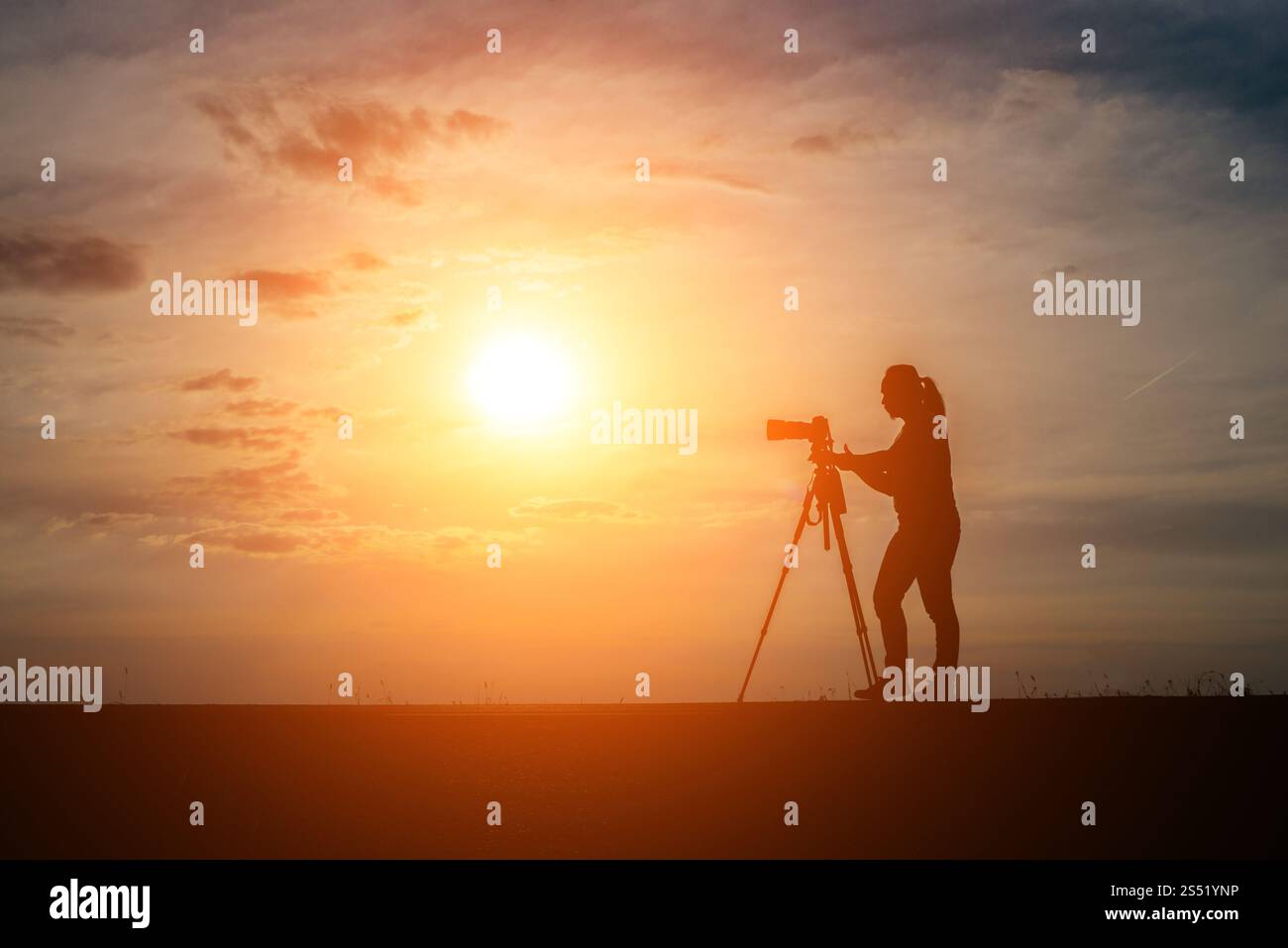 Silhouette di un fotografo spara un tramonto. Foto Stock