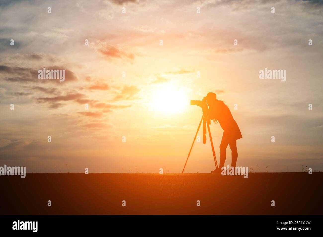 Silhouette di un fotografo spara un tramonto. Foto Stock