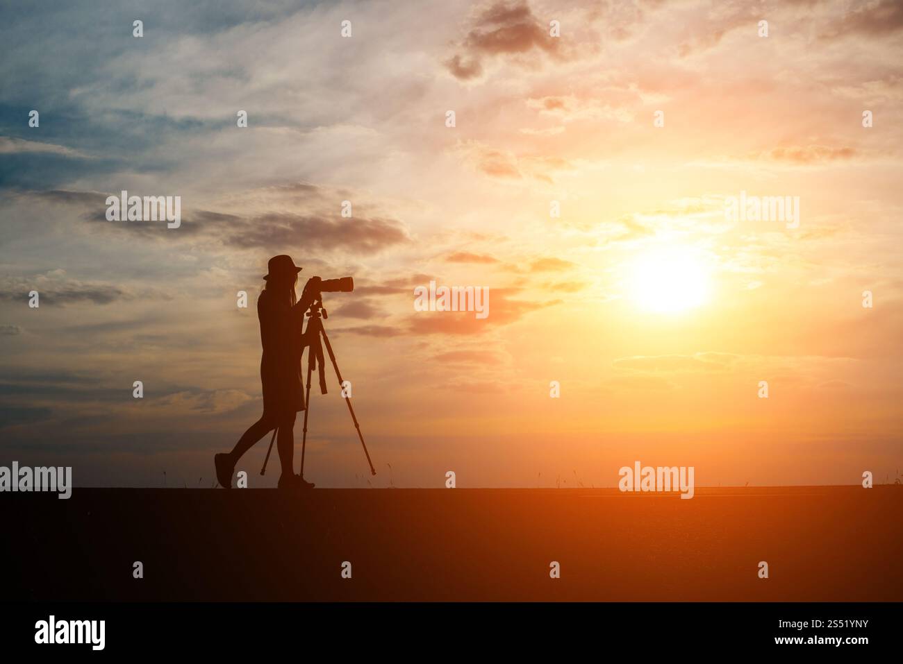 Silhouette di un fotografo spara un tramonto. Foto Stock