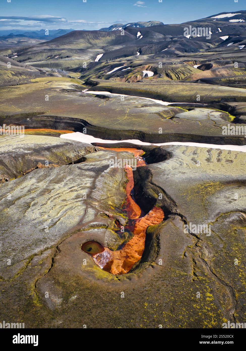 Veduta aerea di un fiume rosso ricco di depositi di ferro nelle Highlands islandesi, circondato da paesaggi vulcanici e natura selvaggia incontaminata. Foto Stock