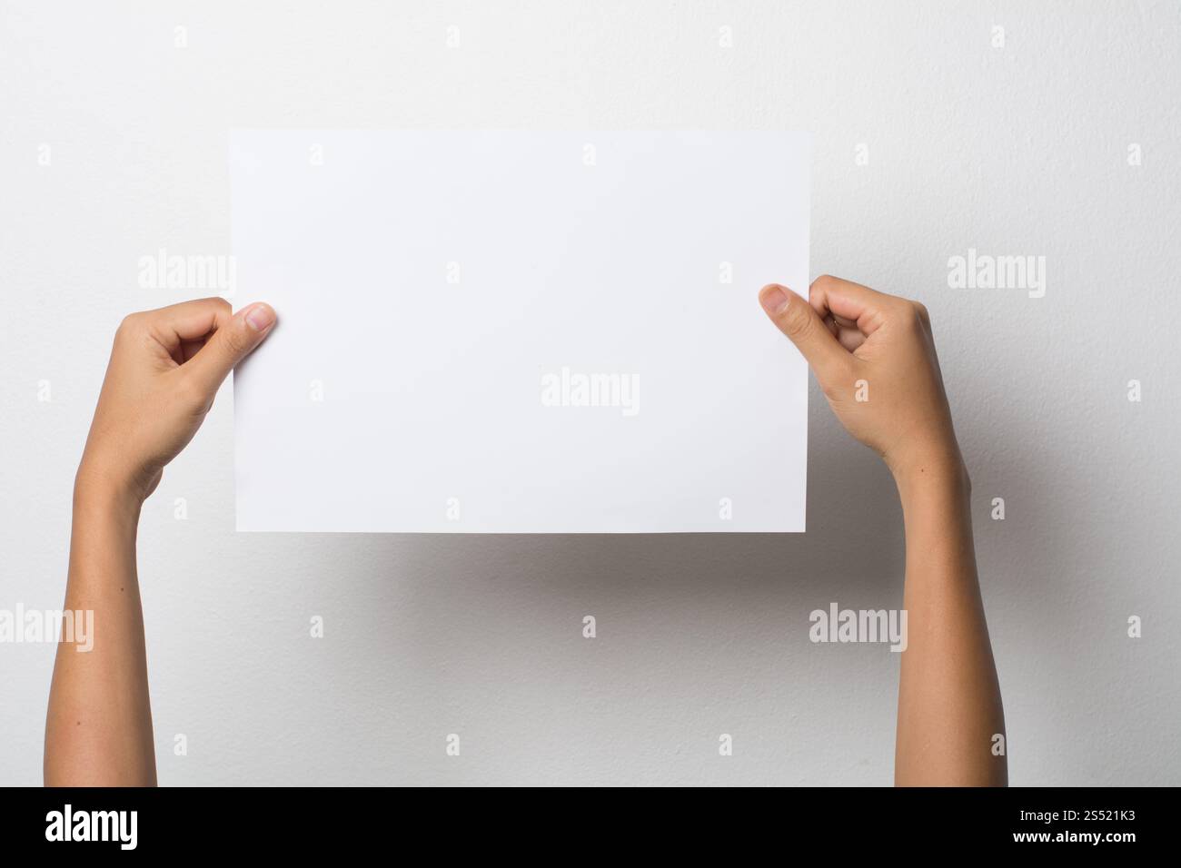 Primo piano di una donna che tiene a mano carta bianca isolata su bac bianco. Primo piano di una donna che tiene a mano carta bianca isolata su sfondo bianco Foto Stock