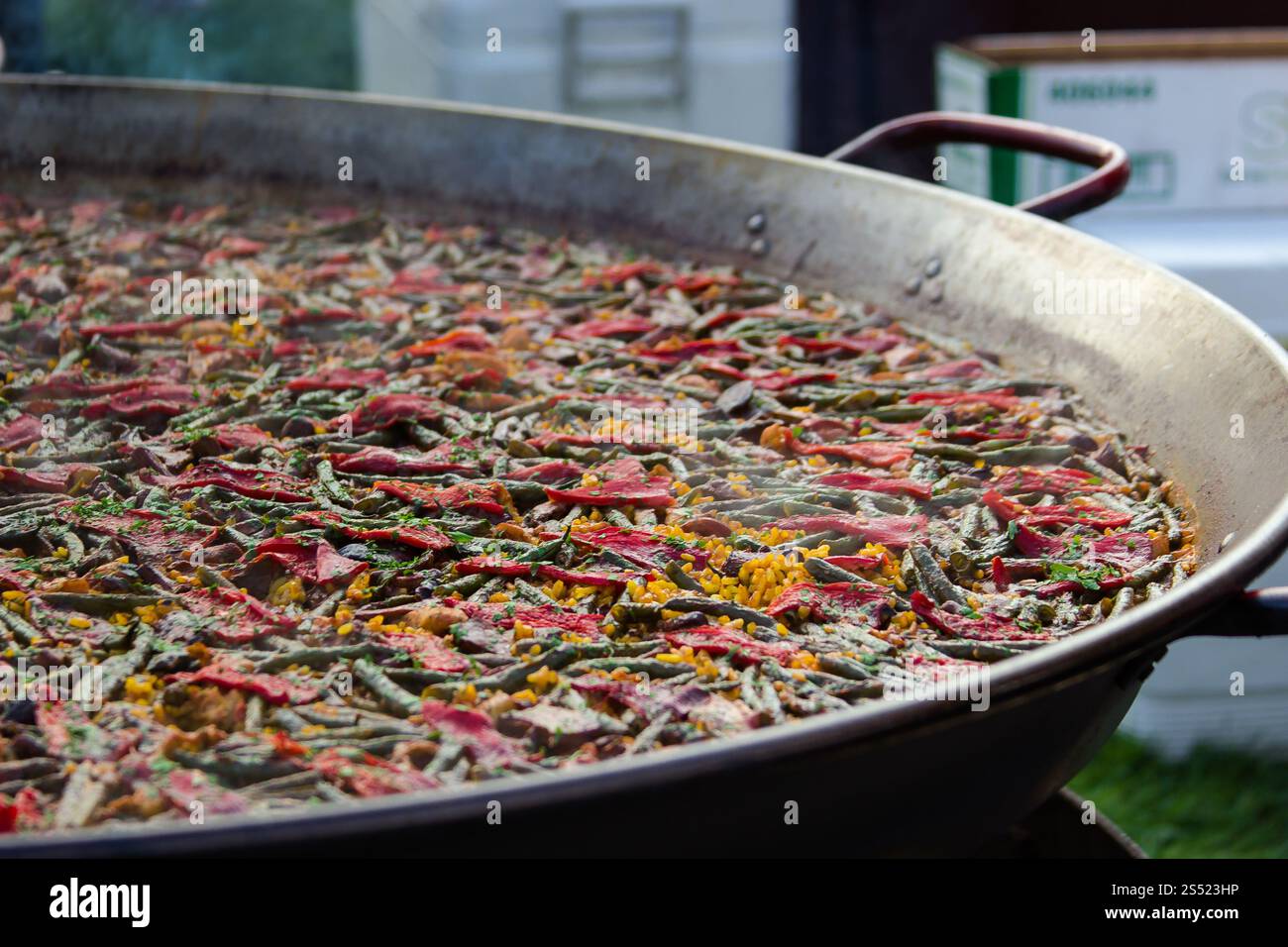 Grande paella spagnola tradizionale che cucina all'aperto con ingredienti freschi Foto Stock