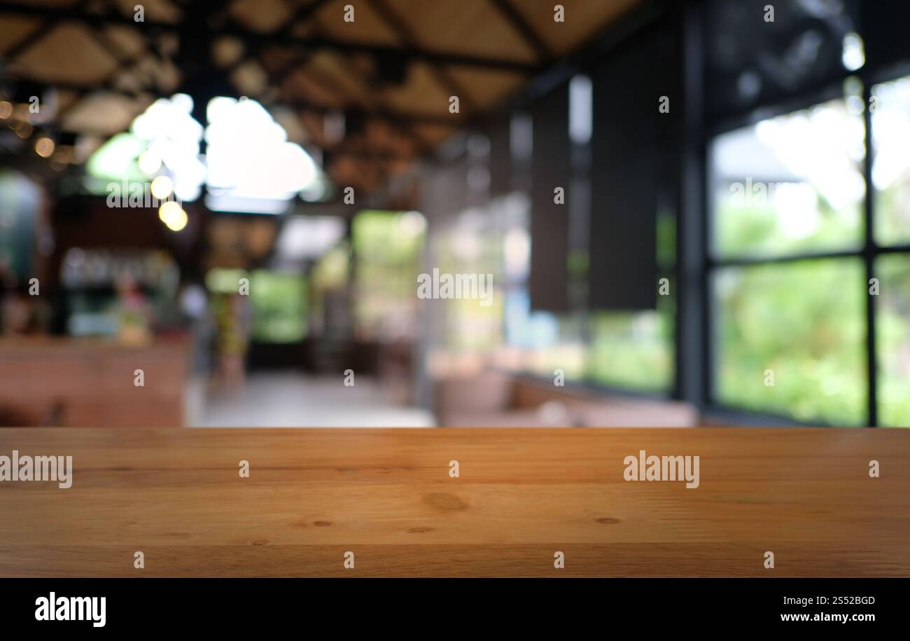 Tavolo vuoto di legno scuro davanti allo sfondo bokeh astratto e sfocato del ristorante. può essere utilizzato per la visualizzazione o il montaggio dei prodotti. Mock-up per Foto Stock