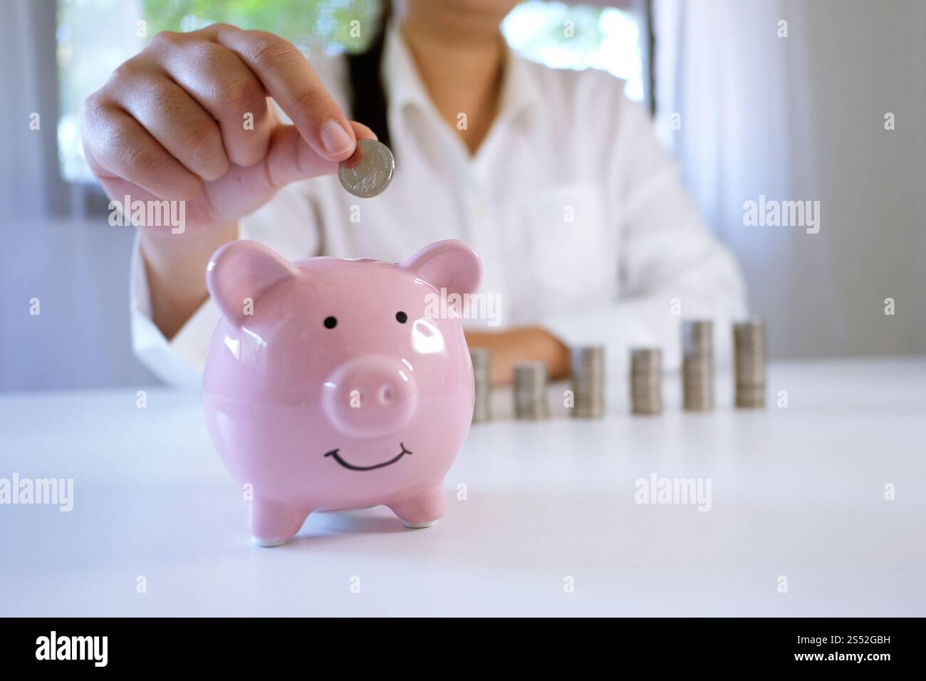 Le mani femminili accumulano monete in crescita. Risparmio di denaro Foto Stock