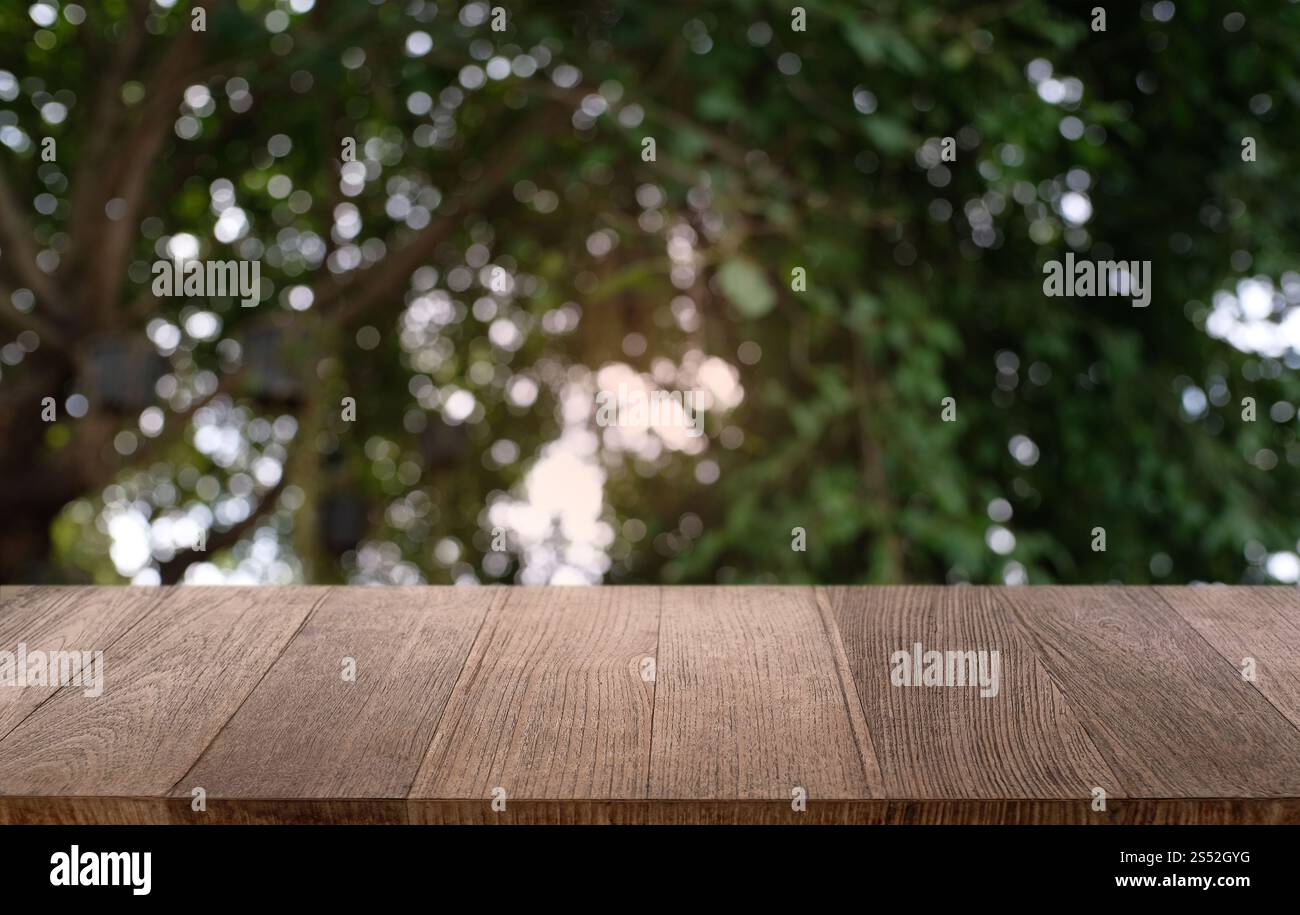 Tavolo vuoto di legno scuro davanti allo sfondo bokeh astratto e sfocato del ristorante. può essere utilizzato per la visualizzazione o il montaggio dei prodotti. Mock-up per Foto Stock