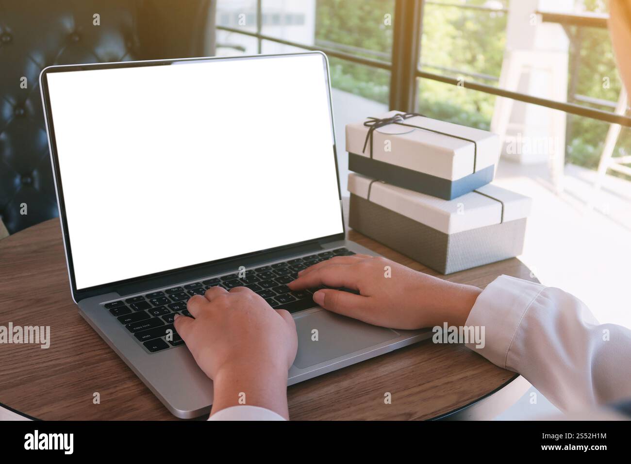Uomo che lavora utilizzando un computer portatile su un tavolo di legno. Digitazione con le mani su una tastiera Foto Stock