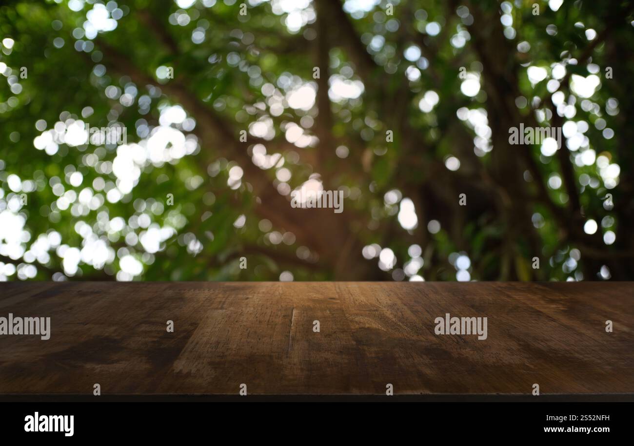 Tavolo vuoto di legno scuro davanti allo sfondo bokeh astratto e sfocato del ristorante. può essere utilizzato per la visualizzazione o il montaggio dei prodotti. Mock-up per Foto Stock