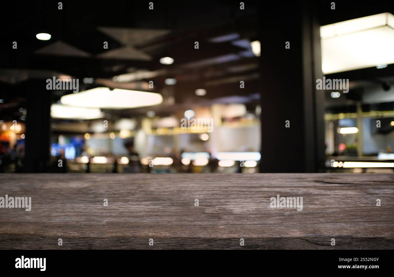 Svuotare tavolo in legno e superiore di sfocatura di notte sullo sfondo di mercato/messa a fuoco selettiva .per montaggio display del prodotto Foto Stock