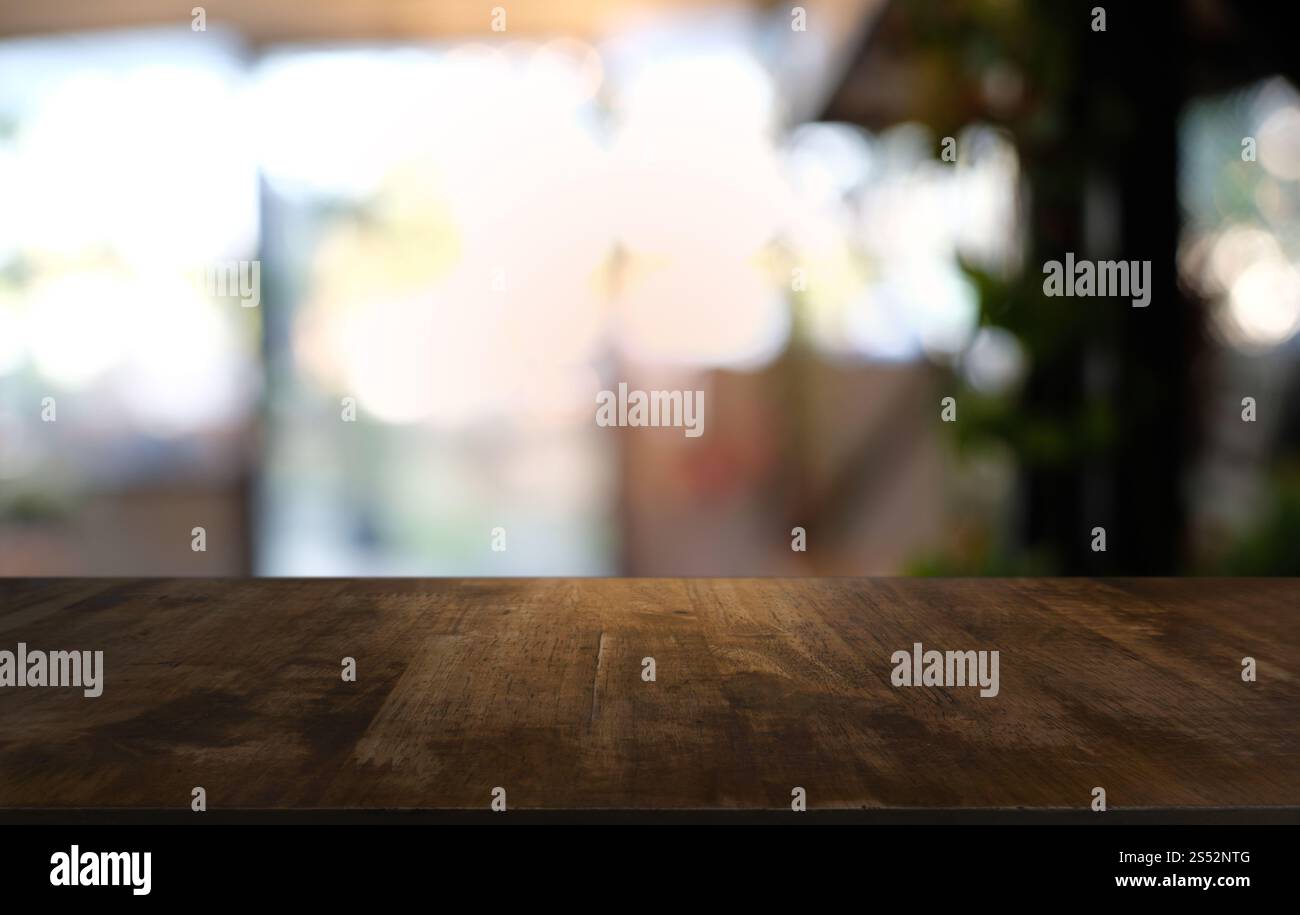 Tavolo vuoto di legno scuro davanti allo sfondo bokeh astratto e sfocato del ristorante. può essere utilizzato per la visualizzazione o il montaggio dei prodotti. Mock-up per Foto Stock