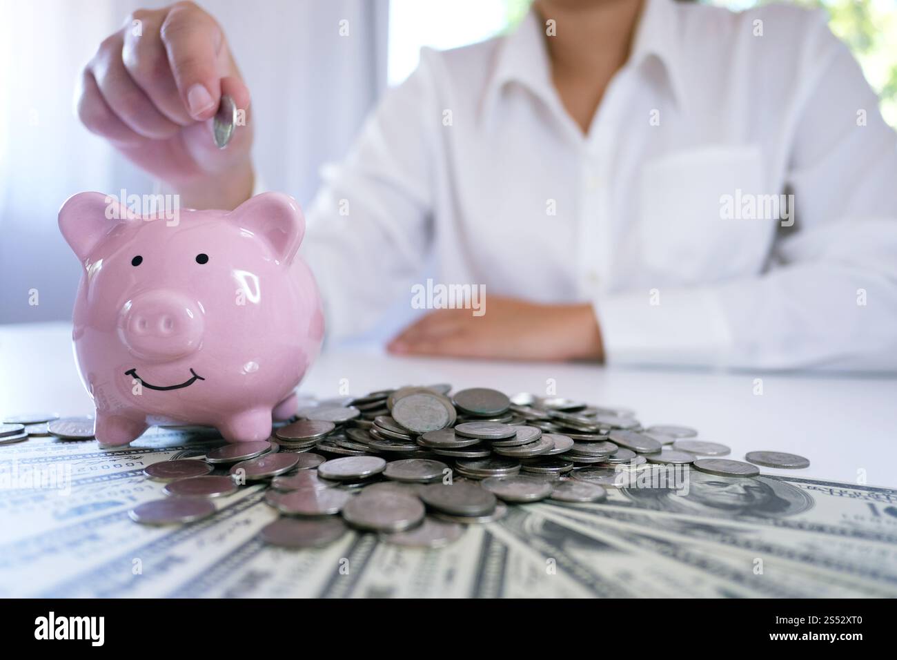 Le mani femminili accumulano monete in crescita. Risparmio di denaro Foto Stock