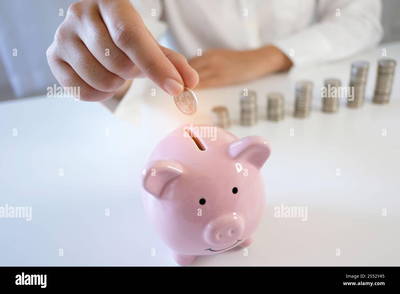 Le mani femminili accumulano monete in crescita. Risparmio di denaro Foto Stock