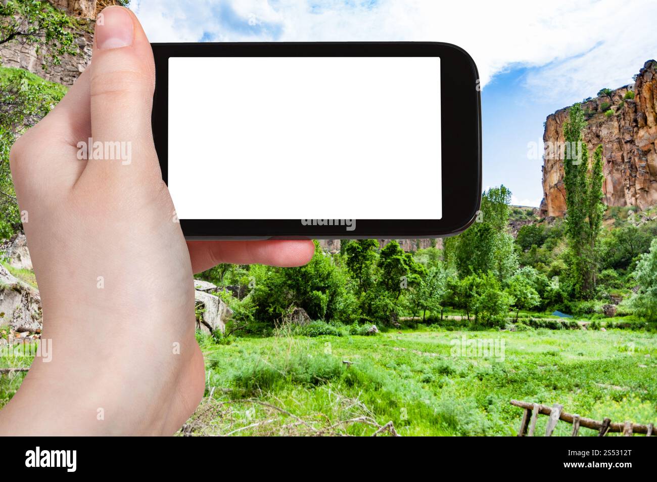 Concetto di viaggio - fotografie turistiche del prato verde nella valle di Ihlara della provincia di Aksaray in Cappadocia in primavera in Turchia su smartphone con vuoto Foto Stock