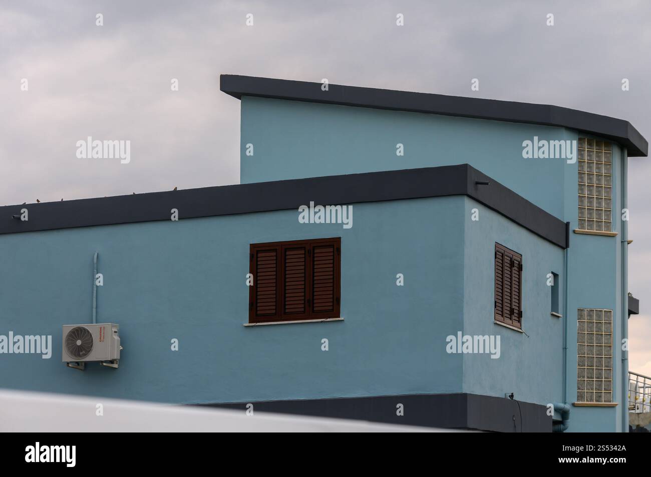 Un suggestivo edificio blu si erge su di un cielo lunare, che mostra le sue linee moderne e caratteristiche architettoniche uniche. Foto Stock