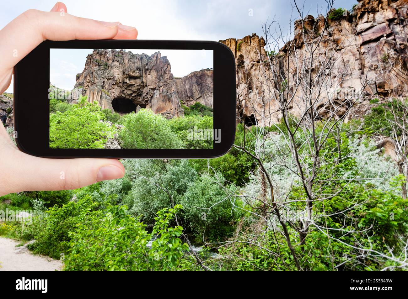 Concetto di viaggio - tourist fotografie della grotta di montagna nella valle di Ihlara di Aksaray Provincia in Cappadocia sullo smartphone in Turchia in primavera Foto Stock