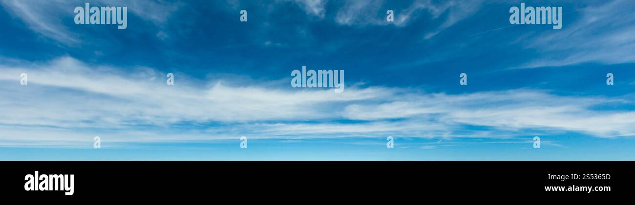 White cirrus nuvole fuzzy nel blu profondo azzurro cielo sopra le montagne. Buona estate meteo sfondo. Foto Stock