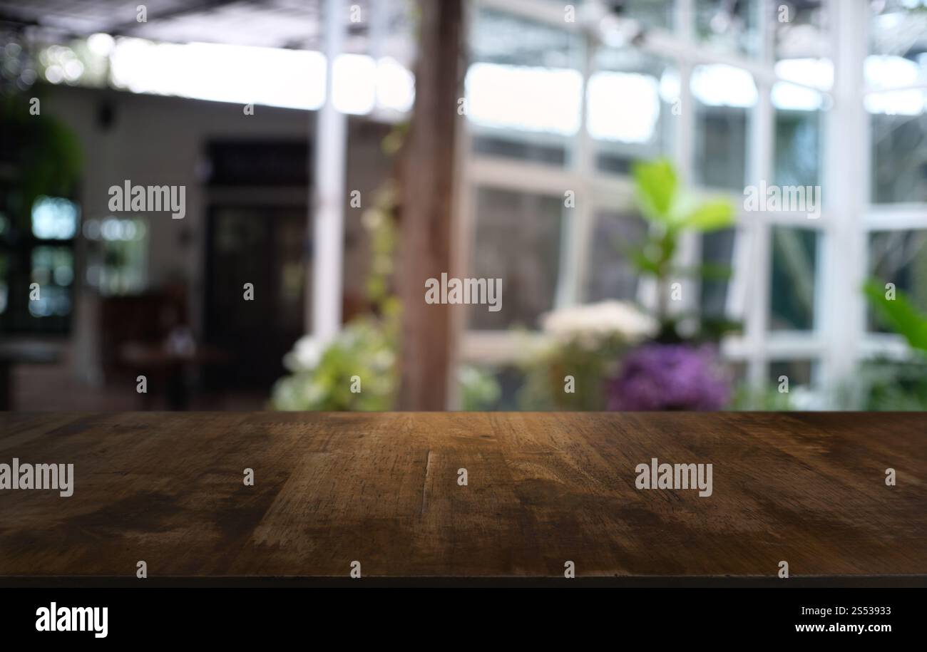 Tavolo vuoto di legno scuro davanti allo sfondo bokeh astratto e sfocato del ristorante. può essere utilizzato per la visualizzazione o il montaggio dei prodotti. Mock-up per Foto Stock