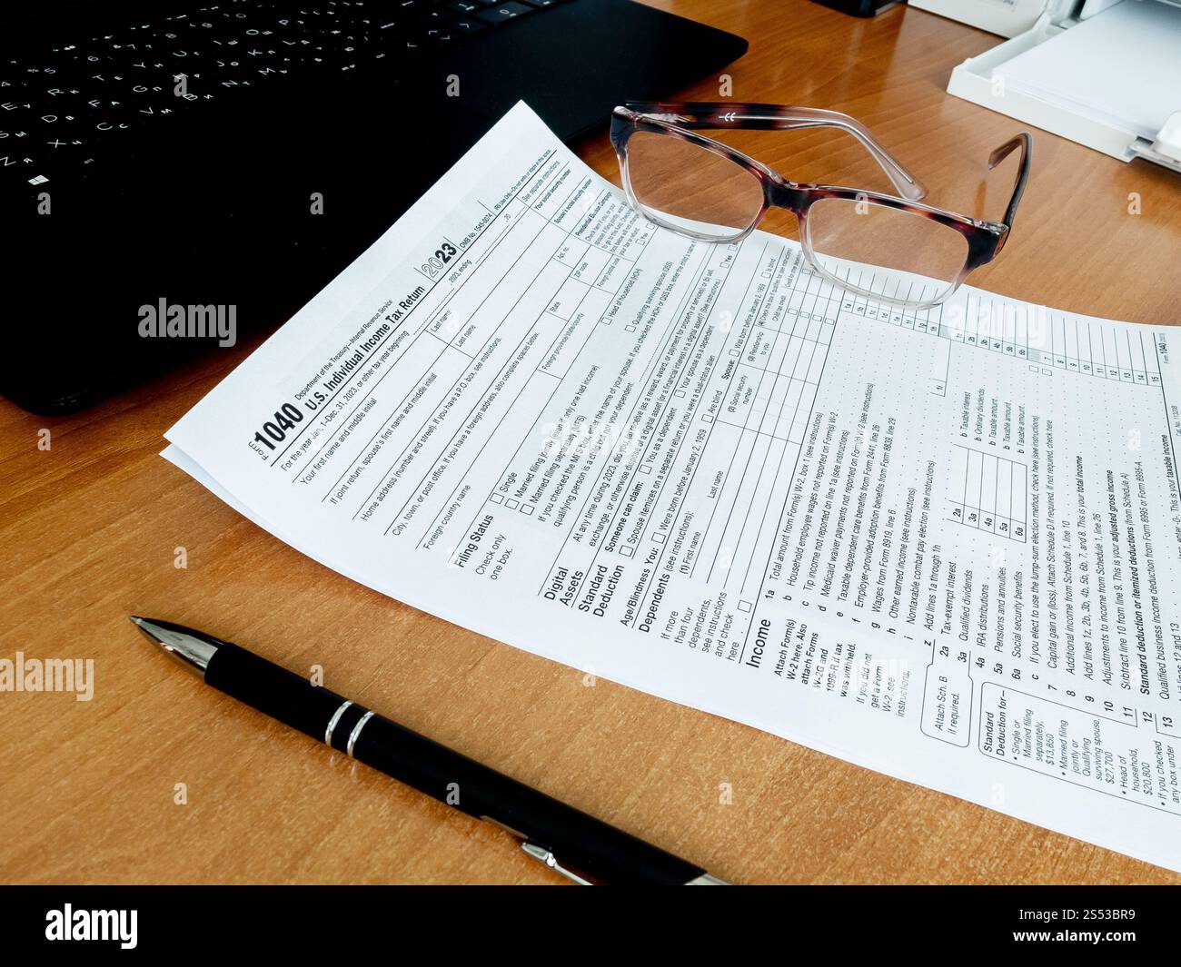 Vista del modulo fiscale 1040 con pennarello e occhiali sulla scrivania dell'ufficio. Documenti, concetto di tassazione Foto Stock