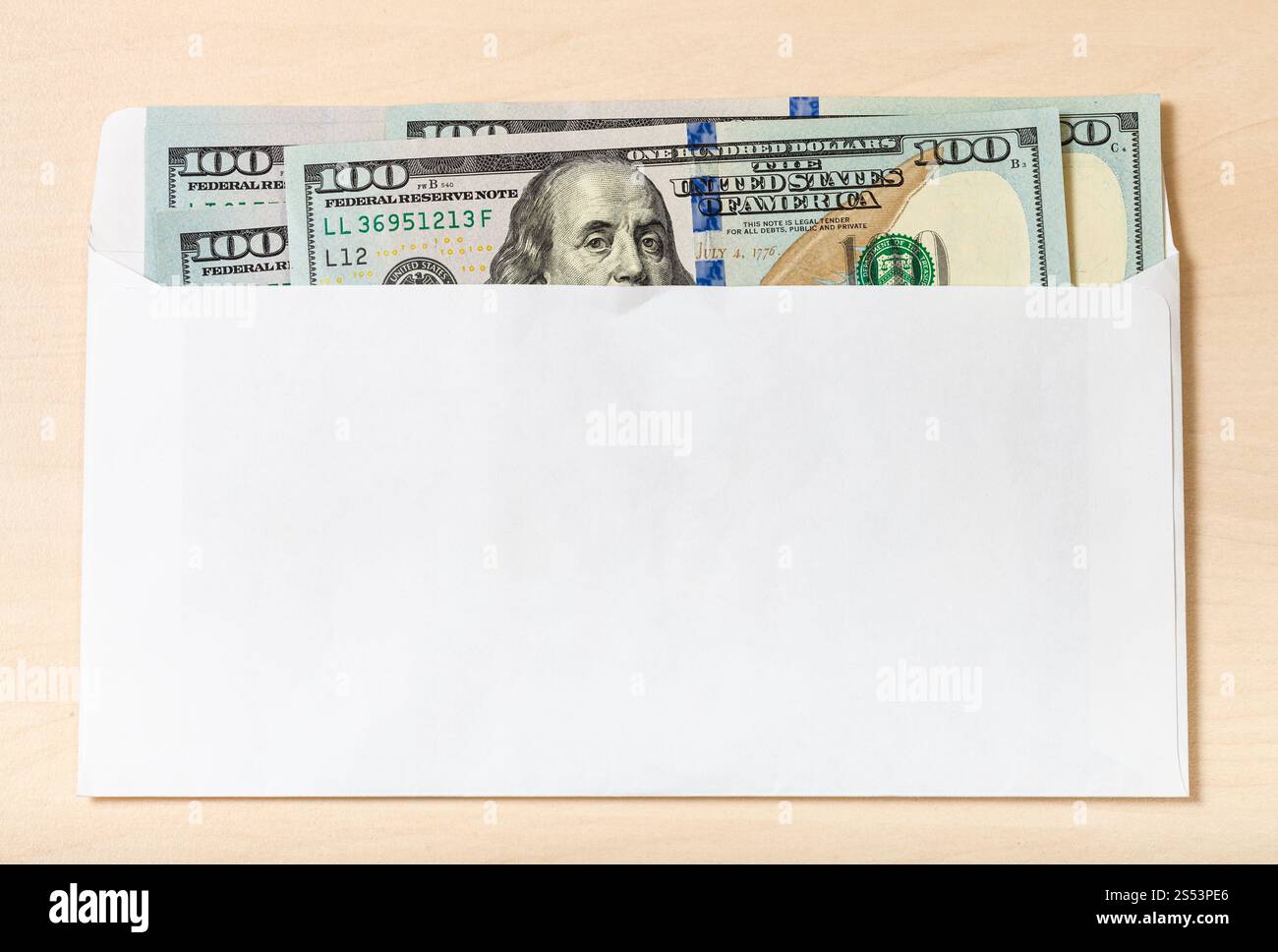Diversi Stati Uniti cento-le fatture del dollaro nella open mail busta sul tavolo di legno Foto Stock