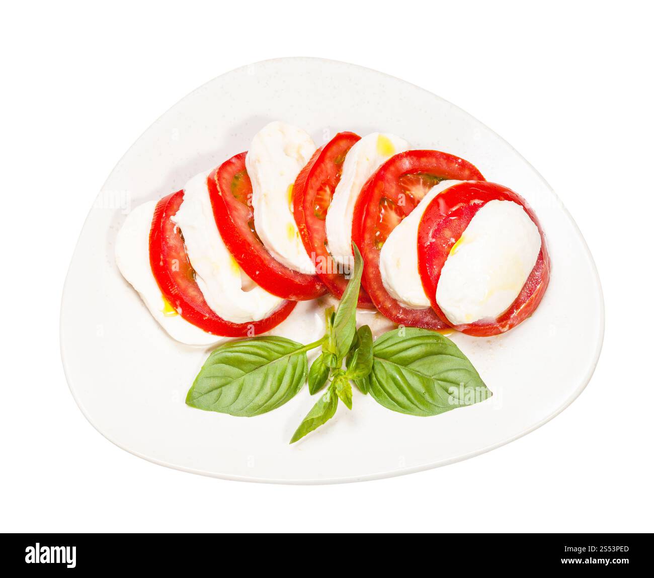 insalata caprese di cucina italiana - vista dall'alto della mozzarella e del pomodoro con ramoscello di basilico su piatto isolato su bianco Foto Stock