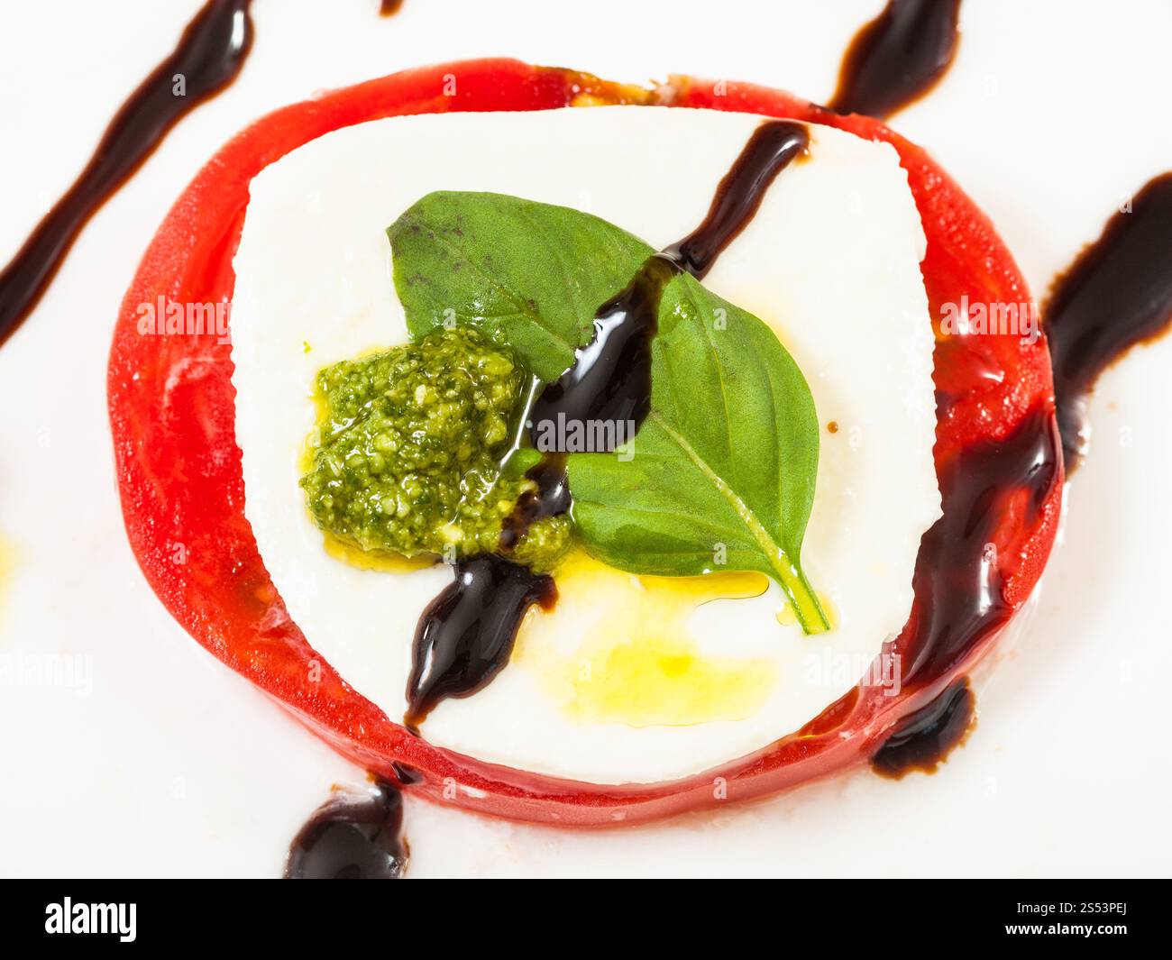 insalata caprese di cucina italiana - vista dall'alto della pila di mozzarella e pomodori con foglie di basilico da vicino conditi da Foto Stock