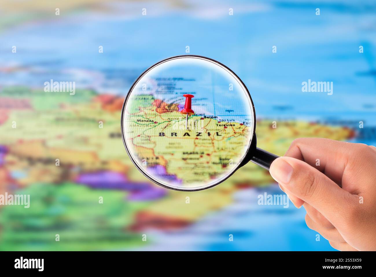 Mano che tiene la lente di ingrandimento Foto Stock