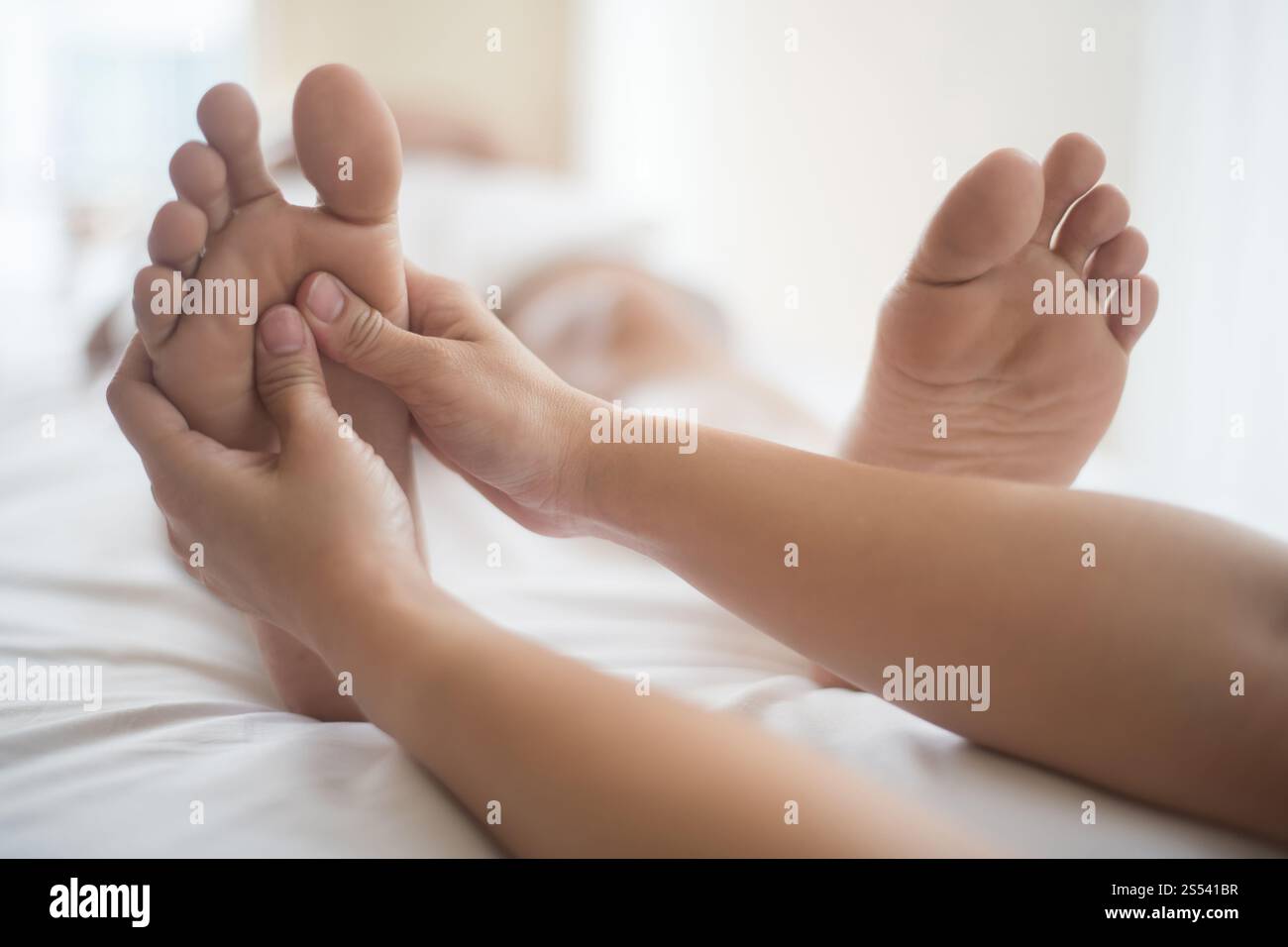 Bella donna con massaggio ai piedi nel salone di bellezza, relax e sano. Foto Stock