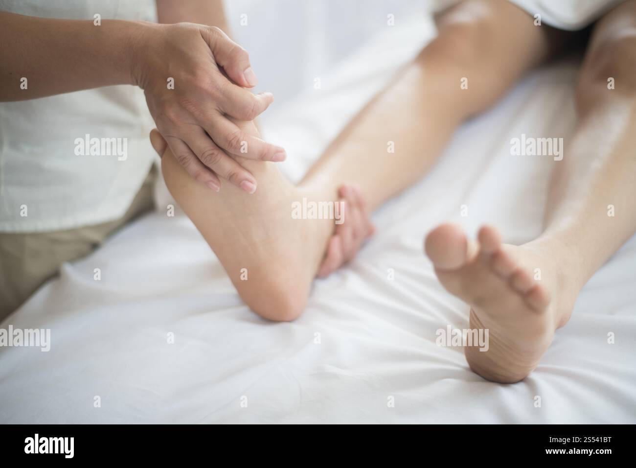 Bella donna con massaggio ai piedi nel salone di bellezza, relax e sano. Foto Stock
