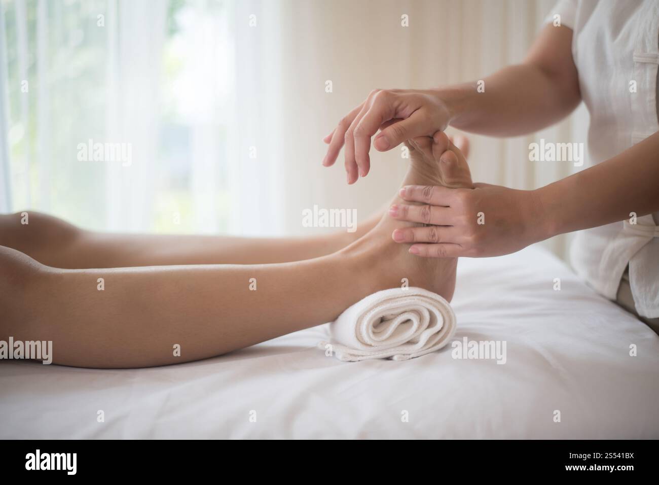 Bella donna con massaggio ai piedi nel salone di bellezza, relax e sano. Foto Stock