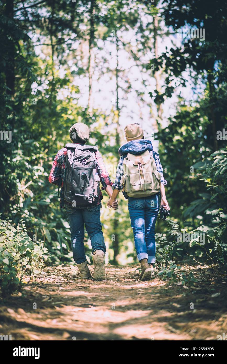 Giovane coppia a piedi con zaini nella foresta. Escursioni avventurose, vacanze insieme, Foto Stock