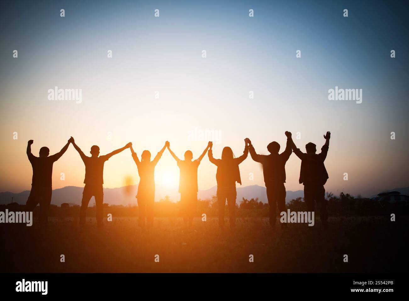 Silhouette di un team di uomini d'affari felice che fa le mani alte sopra la testa nel cielo del tramonto sfondo del tempo serale per il concetto di lavoro di squadra e la libertà Foto Stock