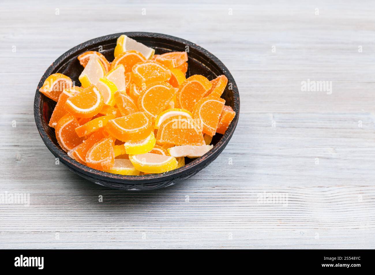 Dolce zucchero e limone Marmellata di arance fette nel recipiente di ceramica su grigio tavolo in legno Foto Stock